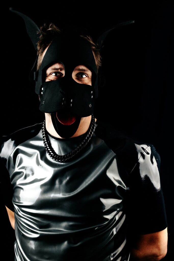 Person in schwarzer Latexkleidung und schwarzer Maske