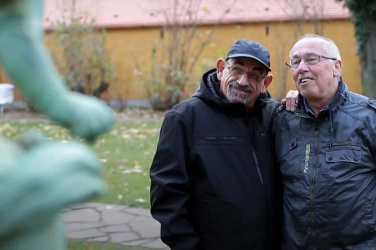 Guido is standing outside with his partner; both are smiling and standing close together.