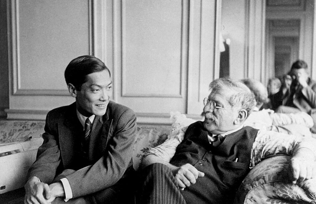 Magnus Hirschfeld (rechts) sitzt auf einem Sofa mit seinem Partner Tao Li.